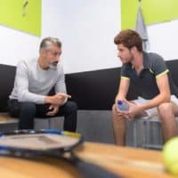 tennis coach talking to player in changing room